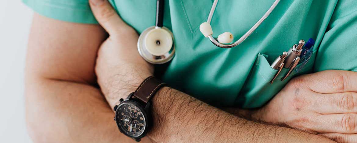 a doctor wearing scrubs, his arms are crossed